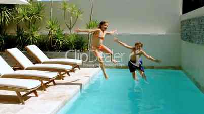 Happy siblings diving into the swimming pool