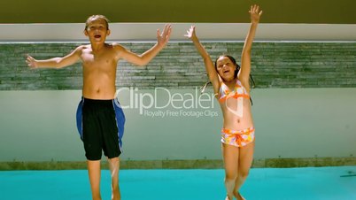 Brother and sister jumping backwards into pool