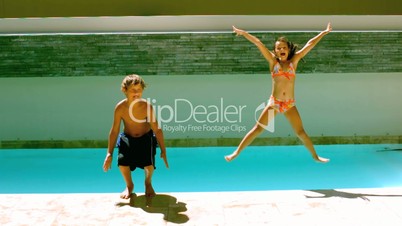 Siblings jumping together in the swimming pool