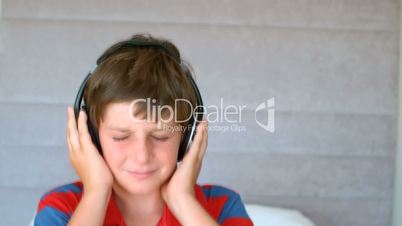 Dancing young boy enjoying music with headphones