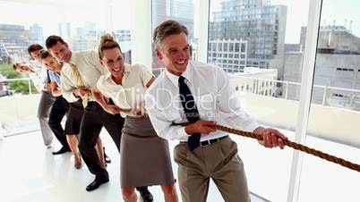 Business people pulling a rope together