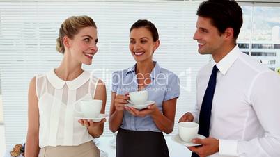 Smiling business people having a conversation at break time