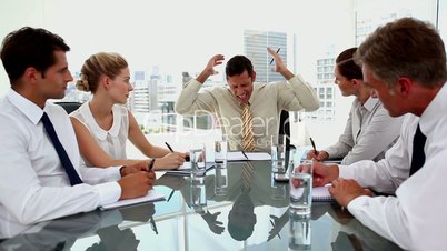 Angry businessman yelling at employees during a meeting