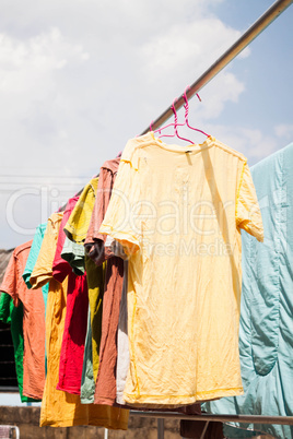 Colorful clothing drying on clothesline under sunlight