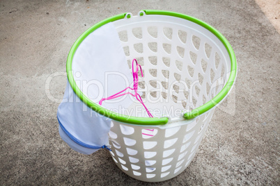 Empty white plastic laundry basket on the floor