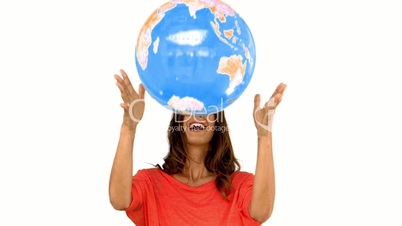 Woman throwing a globe on white background