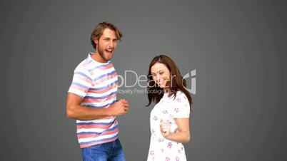 Two friends dancing together on grey background