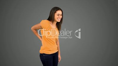 Woman rubbing painful back on grey background