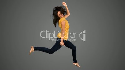 Woman jumping on grey background