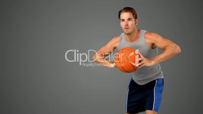 Basketball player passing the ball on grey background