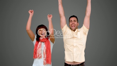 Two friends jumping on grey background