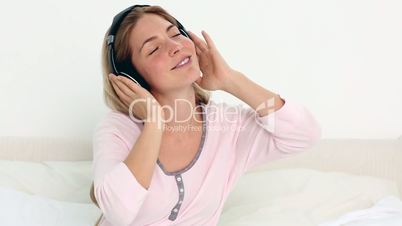Blonde enjoying music in bedroom