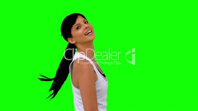 Athletic woman tossing her hair against green screen