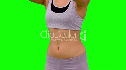 Athletic woman stretching her upper body on green screen
