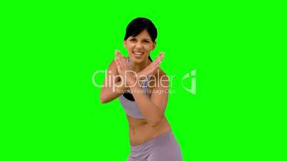 Athletic woman making marital arts pose on green screen