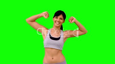 Athletic woman tensing her arms on green screen