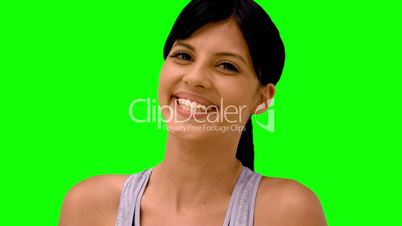 Athletic woman smiling at camera on green screen