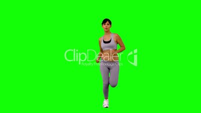 Athletic woman jogging on green screen