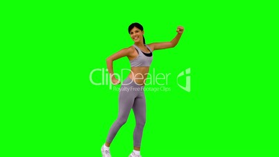 Athletic woman leaping and posing on green screen
