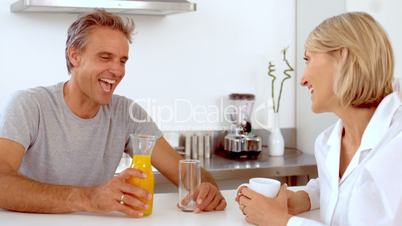 Cheerful man pouring orange juice