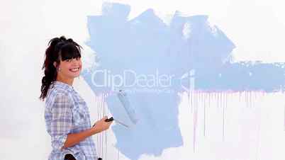 Attractive woman painting her wall