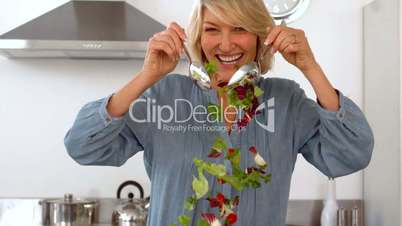 Smiling woman tossing her salad