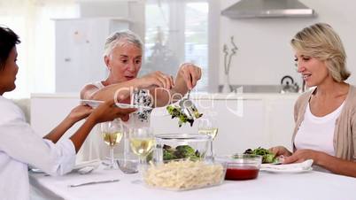 Mature woman offering meal to her friends