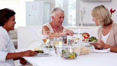 Mature woman serving meal to her friends