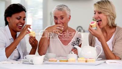 Three mature friends having cup cakes