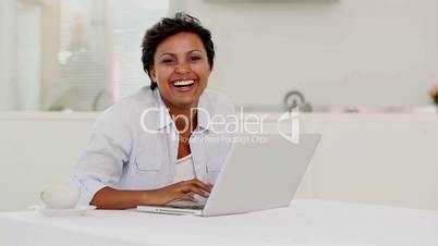 Woman typing on laptop and listening to music