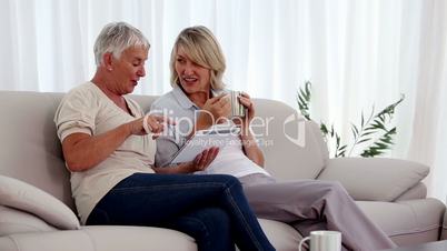 Mature women using tablet pc on the couch