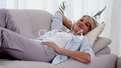 Woman smiling and relaxing on sofa