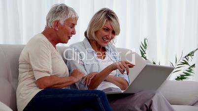 Two friends using a laptop