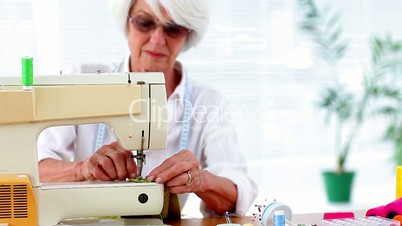 Retired woman using the sewing machine