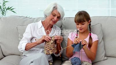 Granny teaching her granddaughter how to knit