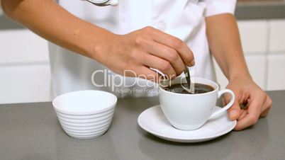 Hand stirring cup of coffee