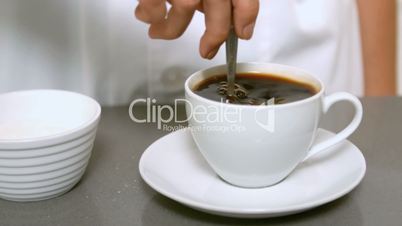 Hand stirring cup of coffee close up