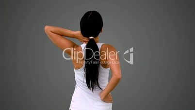 Fit brunette stretching her back and neck