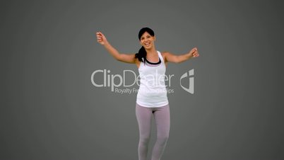 Fit brunette dancing and smiling