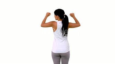 Fit woman tensing arm muscles rear view