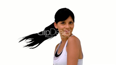 Fit woman tossing her hair and smiling at camera