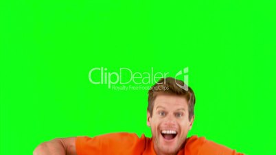 Attractive man jumping in front of the camera on green screen
