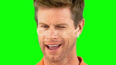 Cheerful man winking an eye on green screen