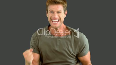 Attractive man gesturing and showing his happiness on grey screen