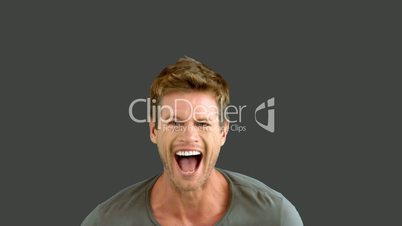Handsome man laughing on grey screen