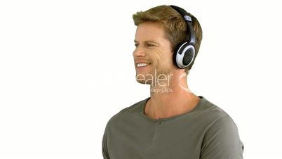Attractive man with headphones listening to music on white background