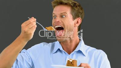 Man savouring a delicious cake on grey screen
