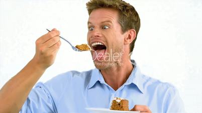 Man savouring a delicious cake on white background