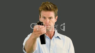 Man using remote on grey screen