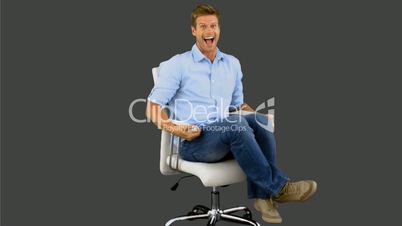 Smiling man turning on swivel on grey screen
